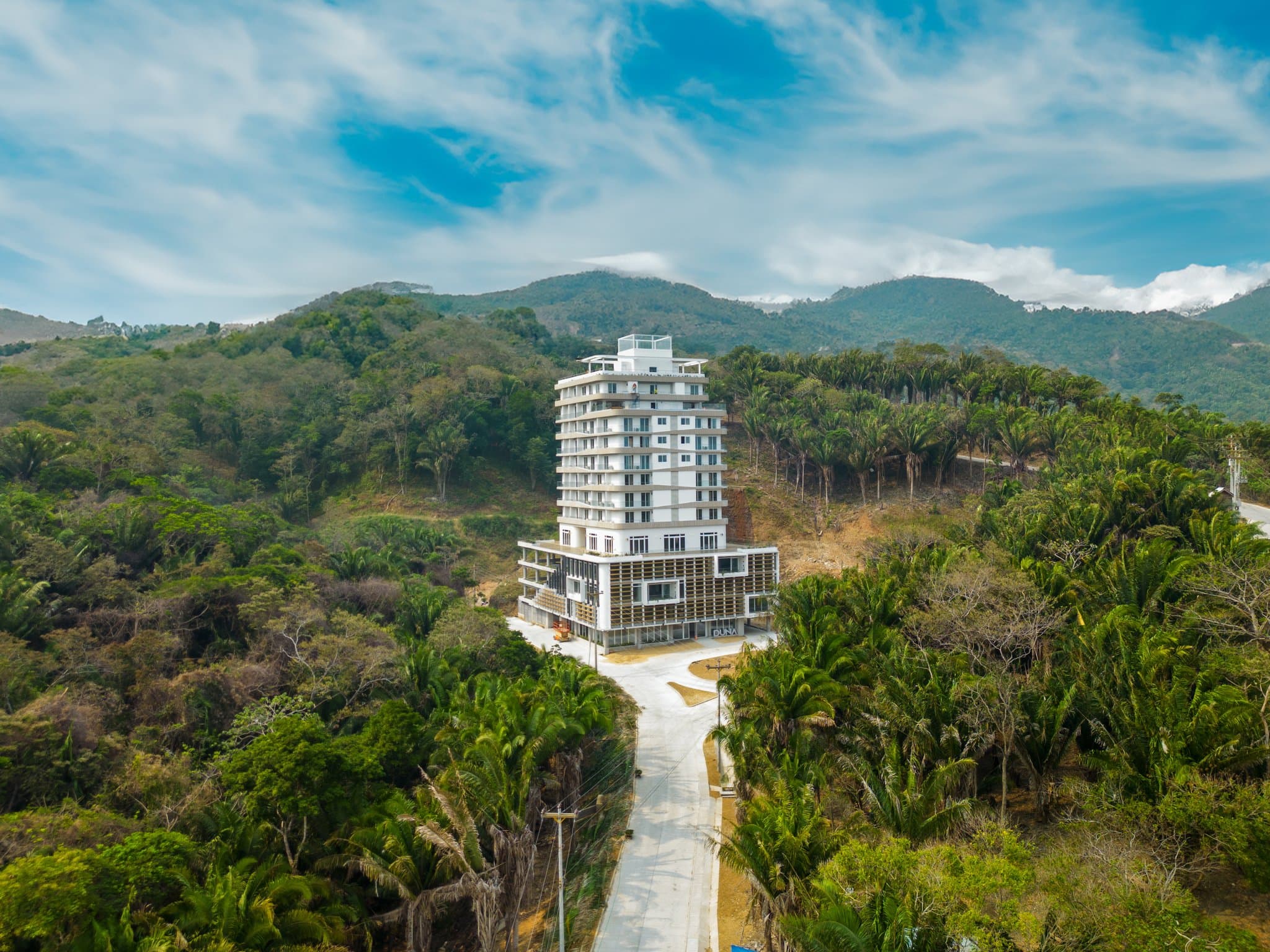 The Duna Residences tower rising above the forest in Próspera, Roatán