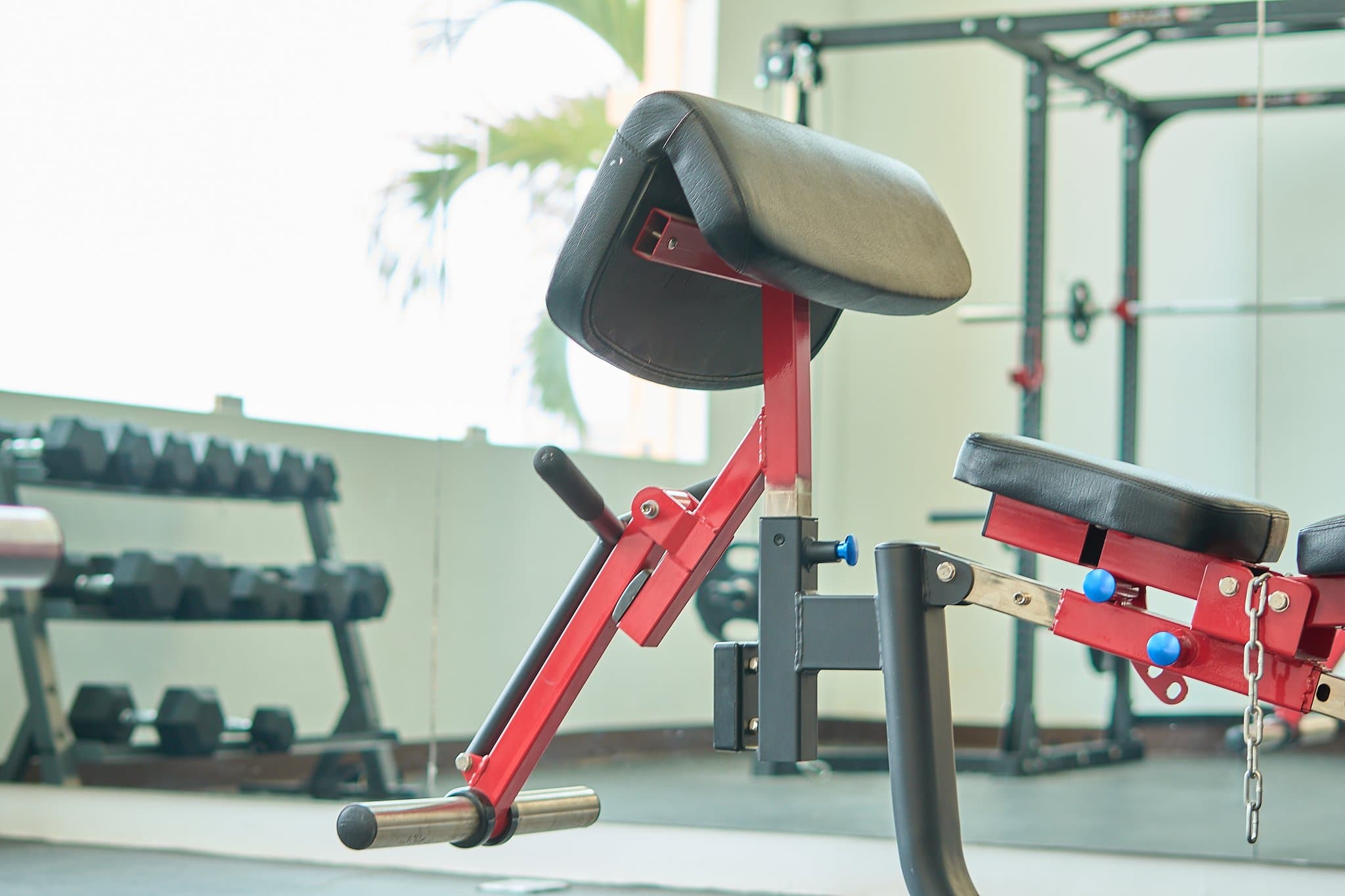 Modern fitness center with equipment and large windows with ocean views.